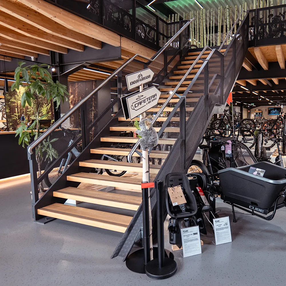 Ansicht einer Treppe aus Holzstufen und Stahlkonstruktion in einem Fahrradladen.